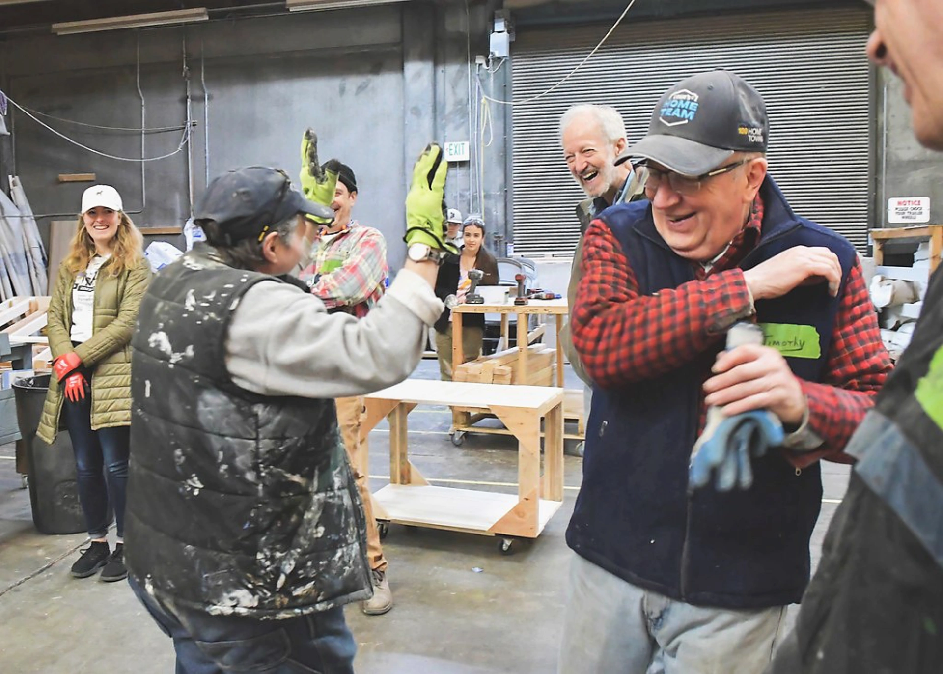 Barb high-fiving a smiling team member in the workshop