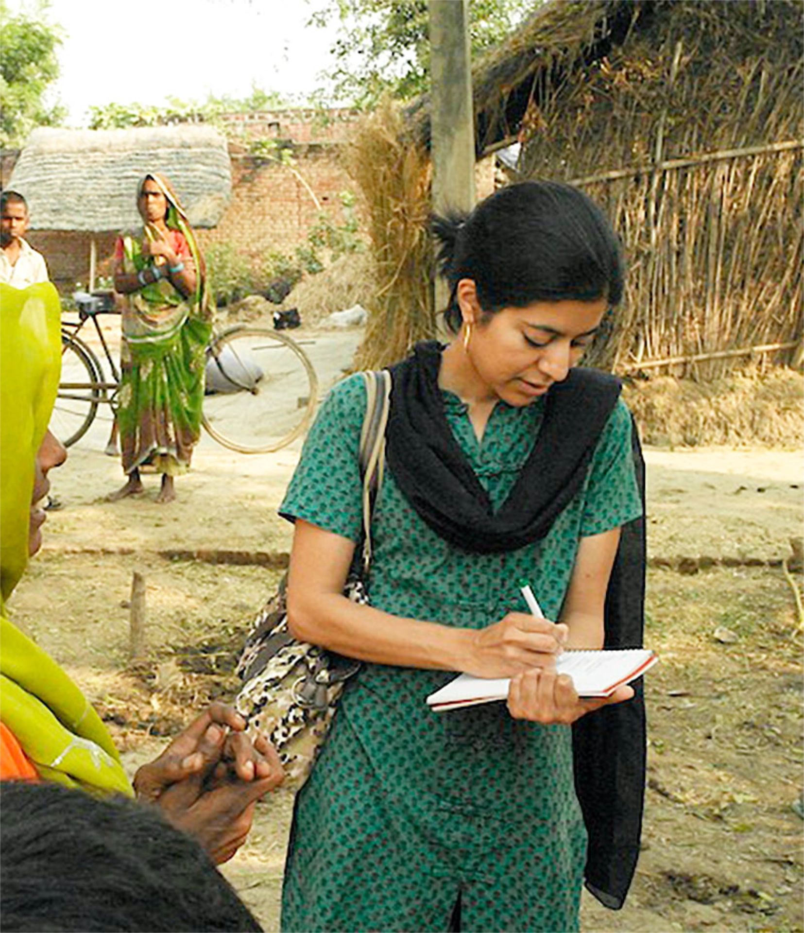 Sachi taking notes while visiting village