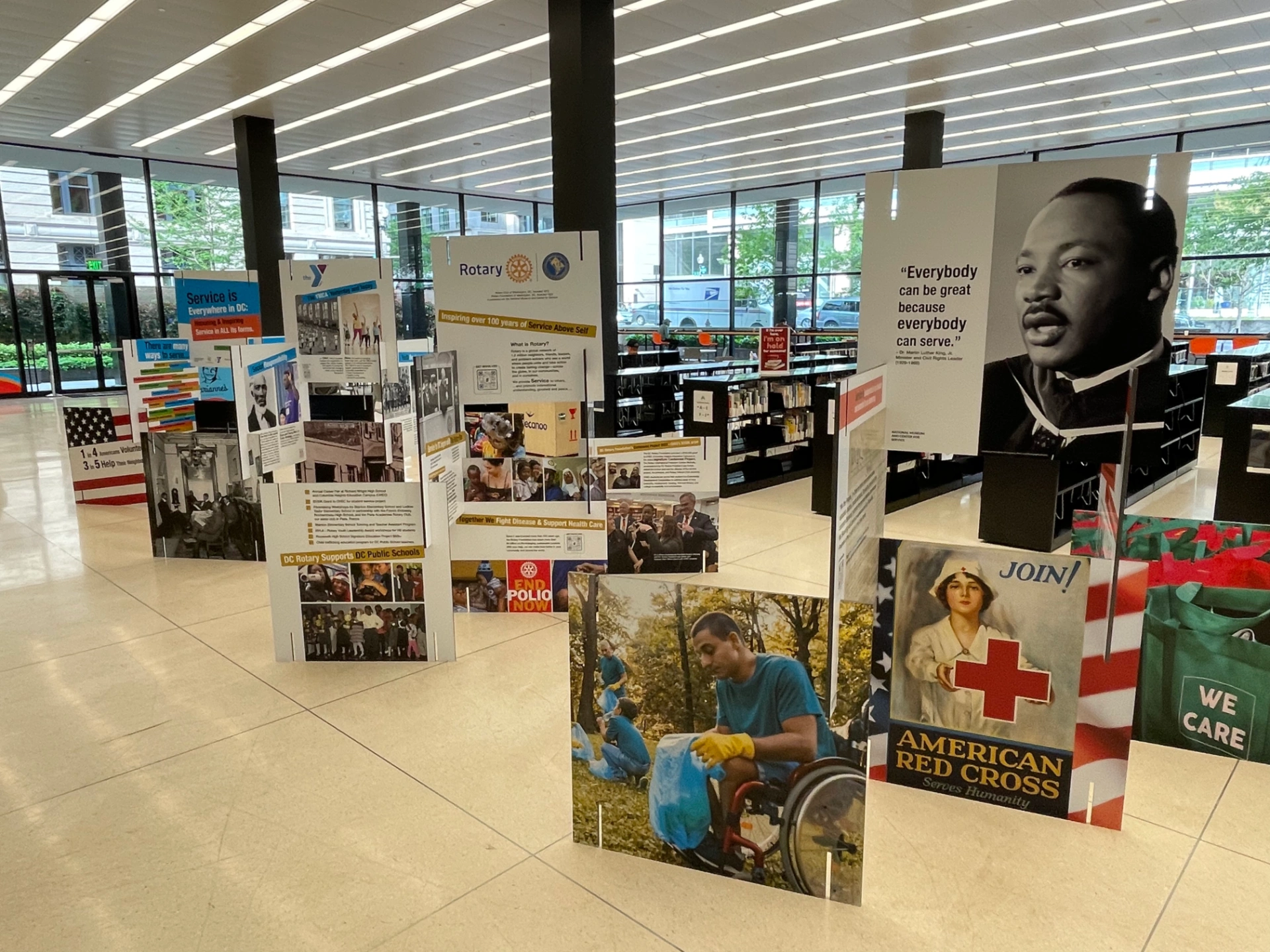 Arranged signs in large open venue showing MLK Jr., images from history of service in the United States, and information about Rotary International