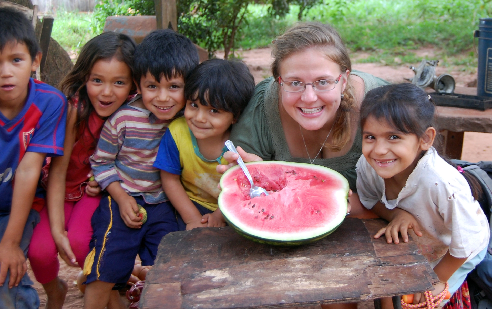 Stephanie shares a joyful moment with children in Paraguay as they enjoy a refreshing watermelon snack together