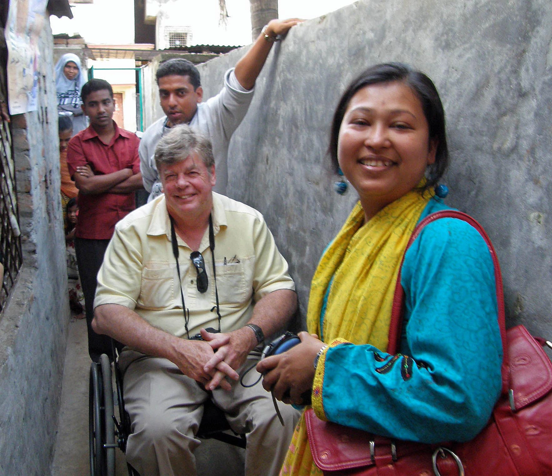 Steve smiling with woman and people behind him