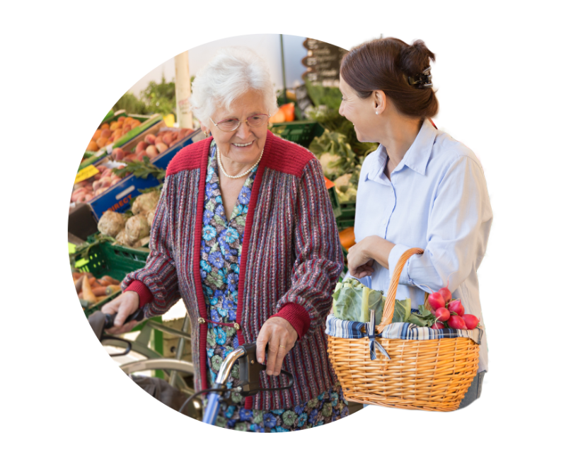 Woman helping senior woman shopping at grocery store, with her shopping basket and head extending outside the circle frame