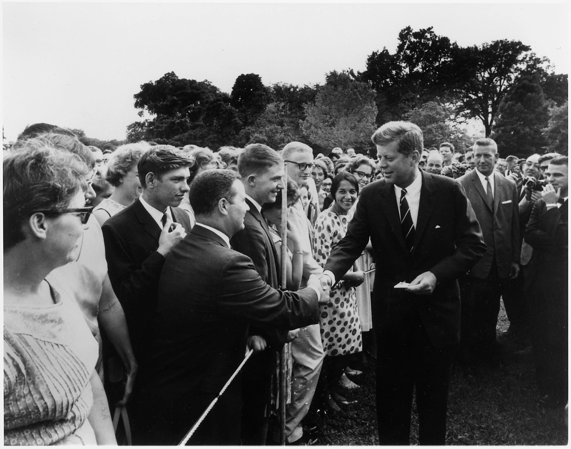 President John F. Kennedy shaking hands with crowd outside