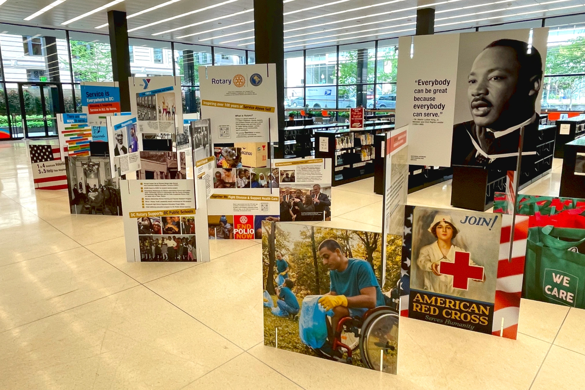 Arranged signs in large open venue showing MLK Jr., images from history of service in the United States, and information about Rotary International
